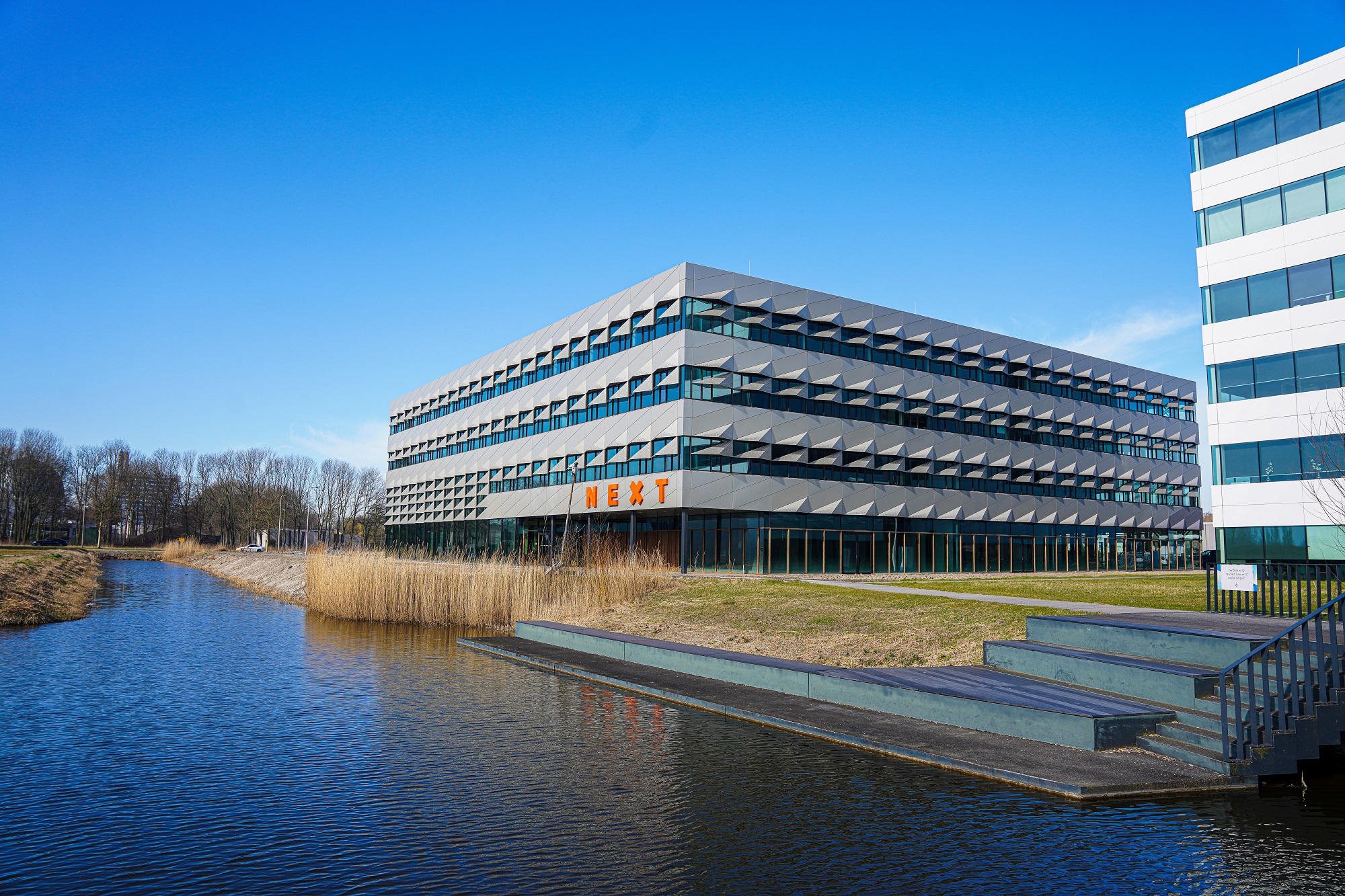 This slide displays NEXT Delft, TU Delft Campus LR.